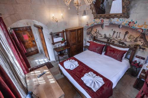 a bedroom with a large bed with red pillows at Göreme Cave Suites in Goreme