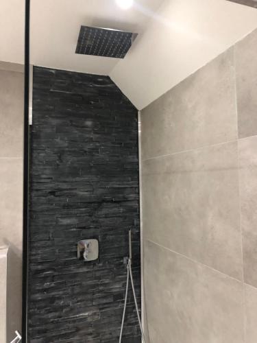 a bathroom with a shower with a stone wall at Bright Family Villa on Dune in Wassenaar in Wassenaar