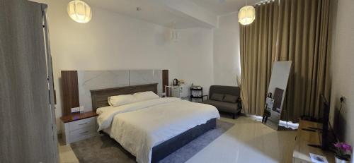 a bedroom with a bed and a chair in it at Wadi View Apartments in Nizwa
