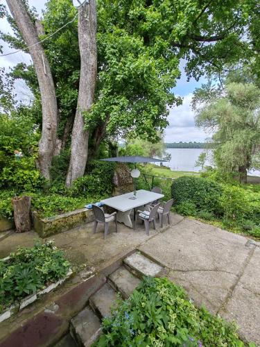 ein Picknicktisch und Stühle mit Blick auf das Wasser in der Unterkunft Varljivo leto, Fruska gora in Čortanovci