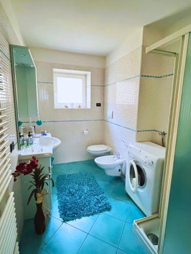 a bathroom with a toilet sink and a washing machine at Casa nel centro di Cembra in Cembra