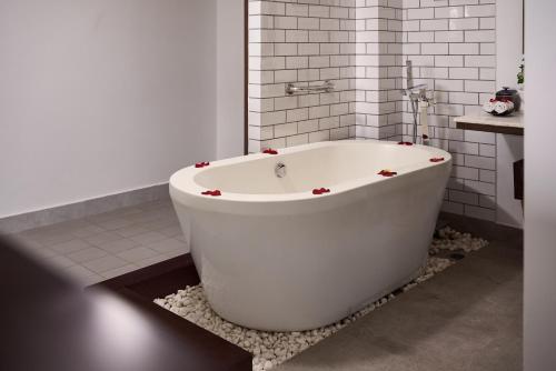 a white bath tub sitting in a bathroom at Hoi An Odyssey Hotel & Spa in Hoi An