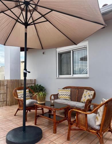 eine Terrasse mit Tisch, Stühlen und Sonnenschirm in der Unterkunft Hidden Loft in Preveza
