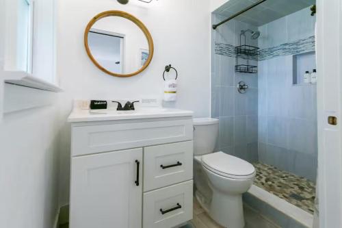 Un baño con inodoro, lavabo y espejo. en Hot Tub 5 min to beach King Bed, en St. Augustine