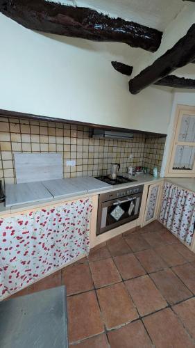 a kitchen with a stove and a counter top at Casa Rural Casaplana, grupos grandes, 1500m2 de casa, piscina privada y patio, 2 barbacoas, Zona Prepirineo in Calasanz