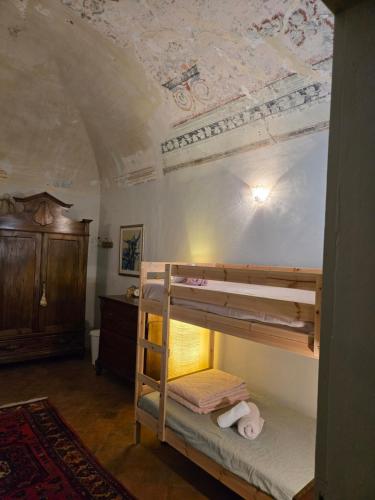 a bedroom with two bunk beds and a ceiling at La Piscina nel Borgo in Bagnone