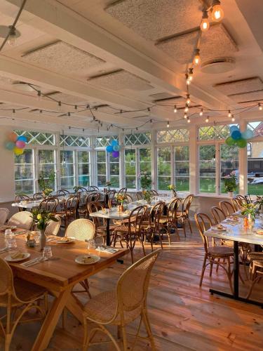 a dining room with tables and chairs and windows at Möja Värdshus in Möja