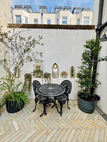 a patio with a table and chairs and a building at Stunning 3 bedroom & 2 bathroom cottage with patio in Brighton & Hove