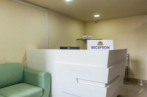 an office with a reception desk and a green chair at Veda pure veg restaurant and residency in Waluj Buzurg