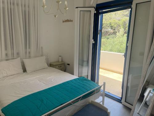 a bedroom with a bed and a sliding glass door at Villa Joseph in Agia Fotia
