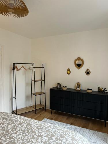 1 dormitorio con vestidor negro y pared blanca en COEUR DE LOTOISE Votre havre de charme au cœur de Gramat, en Gramat