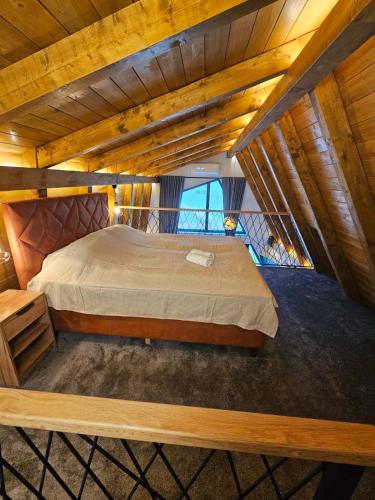 a large bed in a room with wooden ceilings at Luxury Villa Mašić in Čardaci