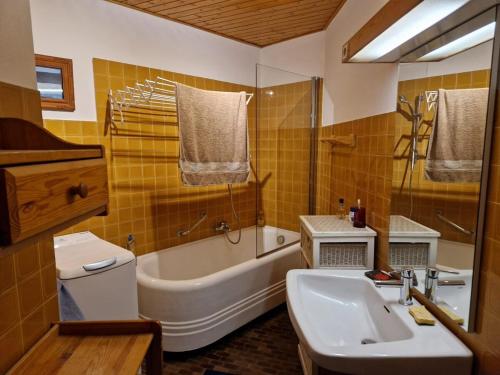une salle de bain avec un lavabo, une baignoire et des toilettes dans l'établissement Spacieux duplex 8 couchages, à Val dʼIsère