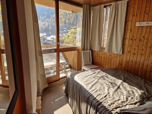 une chambre avec un lit et une grande fenêtre dans l'établissement Spacieux duplex 8 couchages, à Val dʼIsère