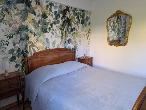 une chambre avec un lit avec un papier peint fleuri dans l'établissement Eucalyptus, calme entouré de verdure et près de la mer, à Saint-Aygulf