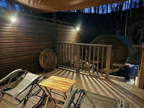 a deck with chairs and a table and a grill at Noël Kitakaruizawa Seiryu-2 Riverside retreat in Tsumagoi