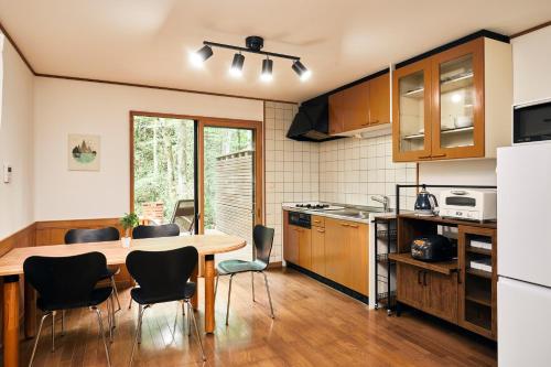 a kitchen with a table and chairs in a kitchen at Noël Kitakaruizawa Seiryu-2 Riverside retreat in Tsumagoi