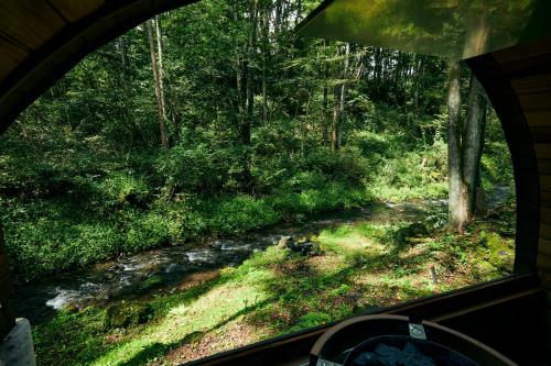 a view from a window of a stream in a forest at Noël Kitakaruizawa Seiryu-2 Riverside retreat in Tsumagoi