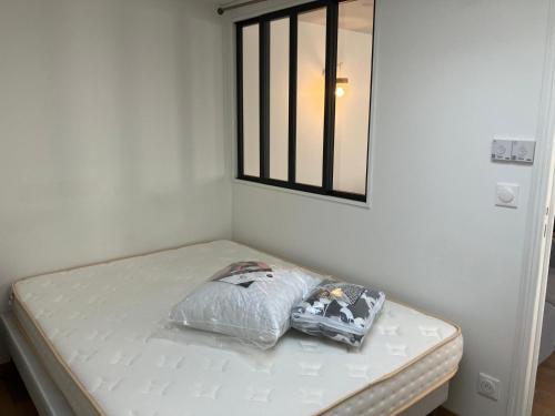 - un lit avec un oreiller dans l'établissement Fluo's small house, à La Courneuve