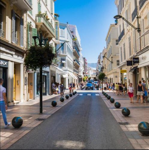 a street in a city with people walking down the street at Cœur de Cannes in Cannes
