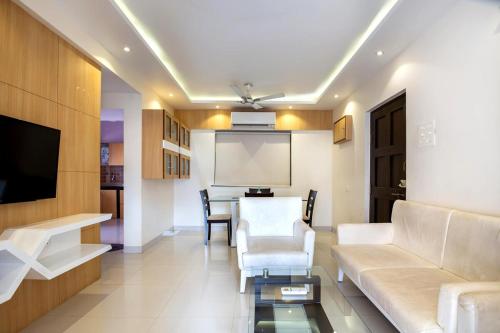a living room with a couch and a table at Luxury 2BHK Apartment with Swimming Pool near Candolim Beach in Candolim