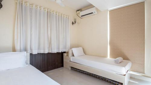 a small room with two beds and a window at Luxury 2BHK Apartment with Swimming Pool near Candolim Beach in Candolim