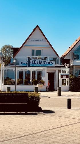 a white building with a sign on the front of it at Maris Ferienwohnung Nr 48 OG mit Balkon und Meerblick in Scharbeutz