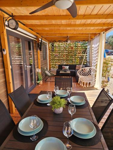 a wooden table with plates and wine glasses on a patio at Peponi Del Mar II in Biograd na Moru
