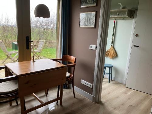 a dining room with a table and chairs and a window at Klein Garnwerd 9 in Garnwerd