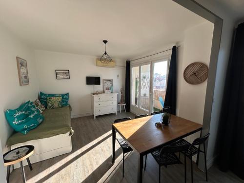 un salon avec un canapé et une table dans l'établissement M T2 climatisé à100m de la plage ,des bateaux ,des commerces, Une terrasse ensoleillée, à Palavas-les-Flots
