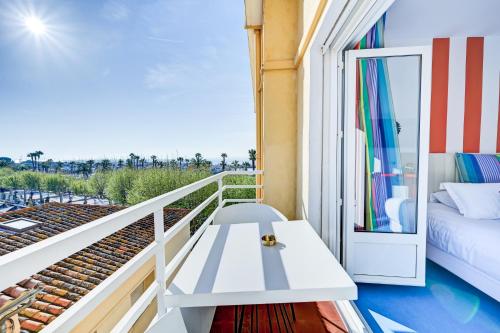 a balcony with a white table and a couch at Hotel Espadon bleu in Le Lavandou