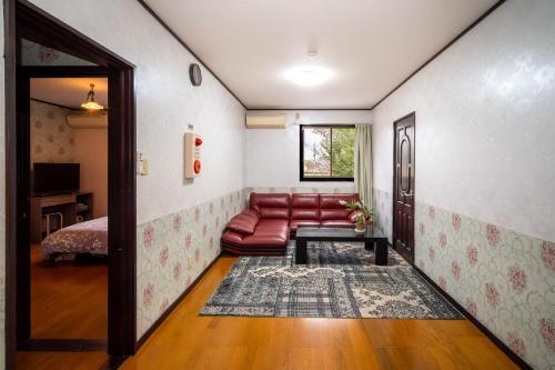 a living room with a red couch and a table at 竹の荘 in Nasukarasuyama