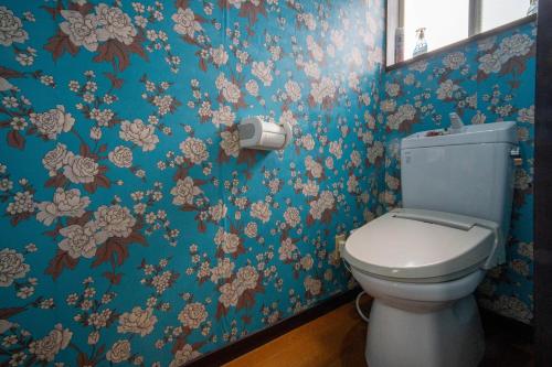 a bathroom with a toilet and floral wallpaper at 竹の荘 in Nasukarasuyama