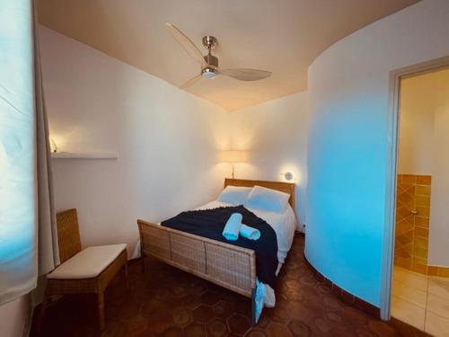 une chambre avec un lit et un ventilateur de plafond dans l'établissement Appartement les pieds dans l eau, à Grimaud