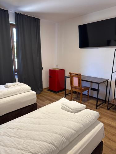 a room with two beds and a table and a television at Hotel am Schloss - Frankfurt an der Oder in Frankfurt/Oder