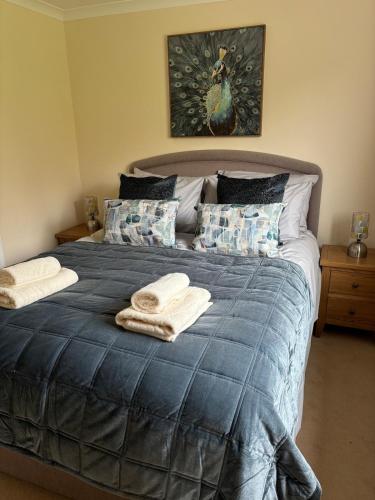 a bedroom with a blue bed with towels on it at The Studio Cottage in Alnwick