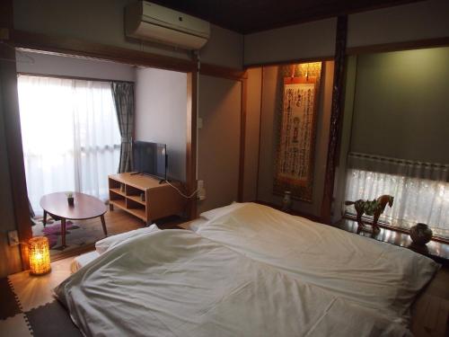 a bedroom with a large white bed and a table at Classy Busshozan - Vacation STAY 15858 in Takamatsu