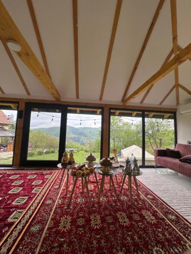 un soggiorno con tavolo su un tappeto rosso di Villa Lux Nature a Sarajevo