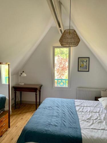 une chambre avec un lit, un bureau et une fenêtre dans l'établissement Le Bocage, maison avec grand jardin et parking, à Étretat