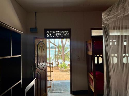 a door leading to a room with a view of the ocean at Kudah Bay Surf Camp in Arugam Bay