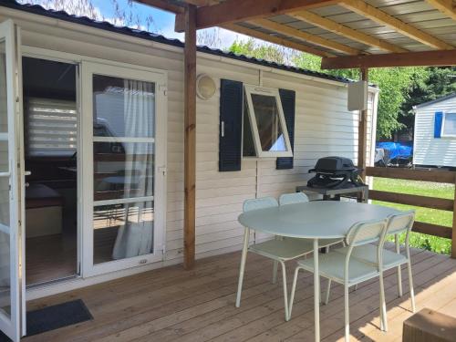 un patio avec une table et des chaises sur une terrasse dans l'établissement Mobil home Embrun, à Embrun