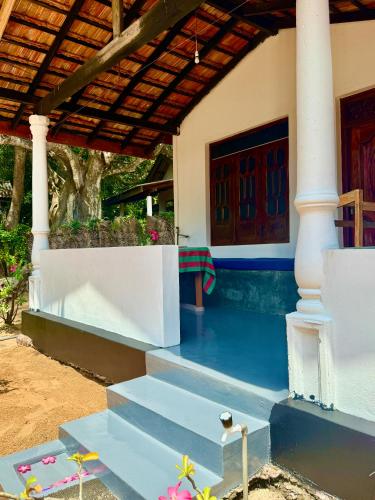 a house with a blue floor and stairs in front at Kudah Bay Surf Camp in Arugam Bay