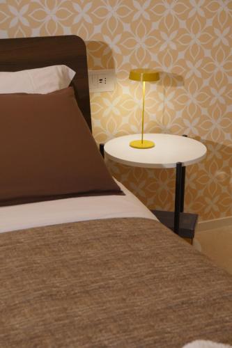 a bedroom with a bed and a table with a lamp at Le Tre Gemme - Luxury Rooms in Ravenna