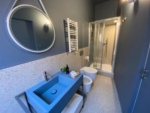a bathroom with a blue sink and a mirror at Le Tre Gemme - Luxury Rooms in Ravenna