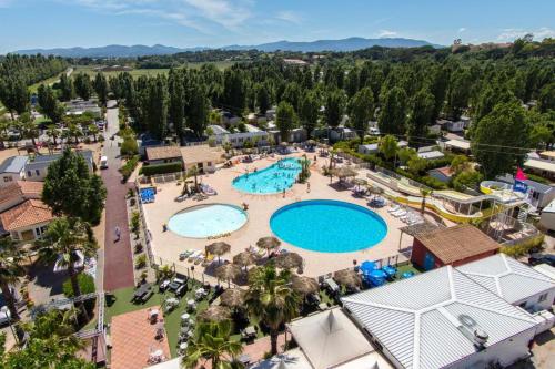 une vue aérienne d'une piscine dans un complexe hôtelier dans l'établissement Mobile home confort - Fréjus - camping 4 étoiles -, à Fréjus