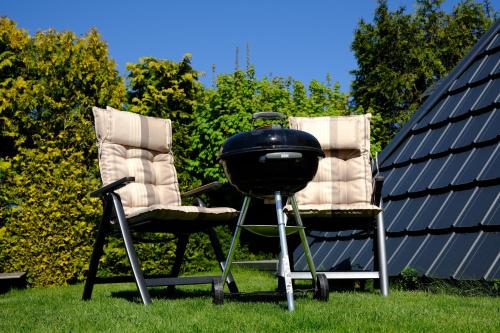 two chairs and a grill next to two chairs at Pyramida pod Lysou s vířivkou in Frýdlant nad Ostravicí