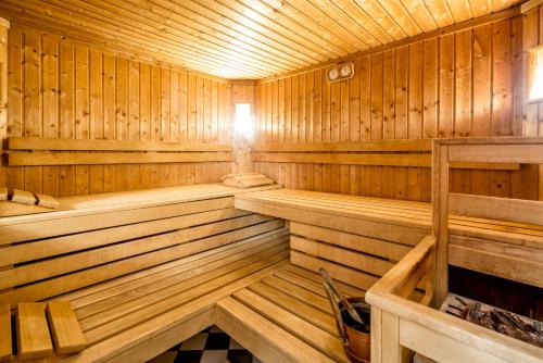 a wooden sauna with wood paneling and a checkered floor at Hotel Weingarten in Caldaro