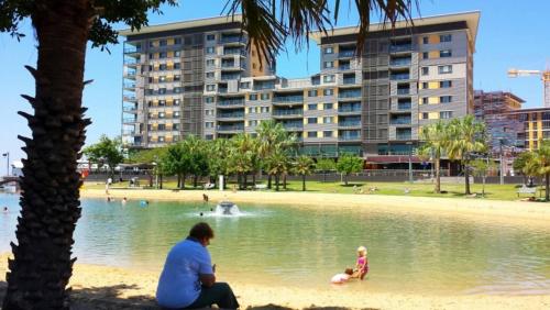 a man and a child playing in the water at a park at Darwin Waterfront Luxury Apartment in Darwin