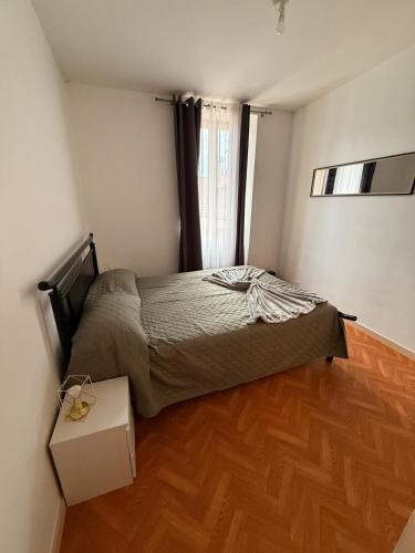 une chambre avec un lit et un parquet dans l'établissement Charming room apartment in a great location, à Thonon-les-Bains