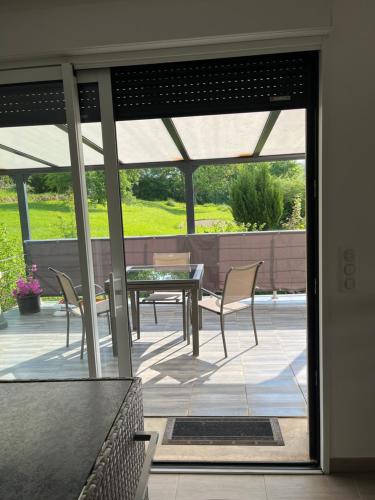 un patio avec une table et des chaises sur un patio dans l'établissement Chez Gino et Nat, à La Celle-sous-Gouzon